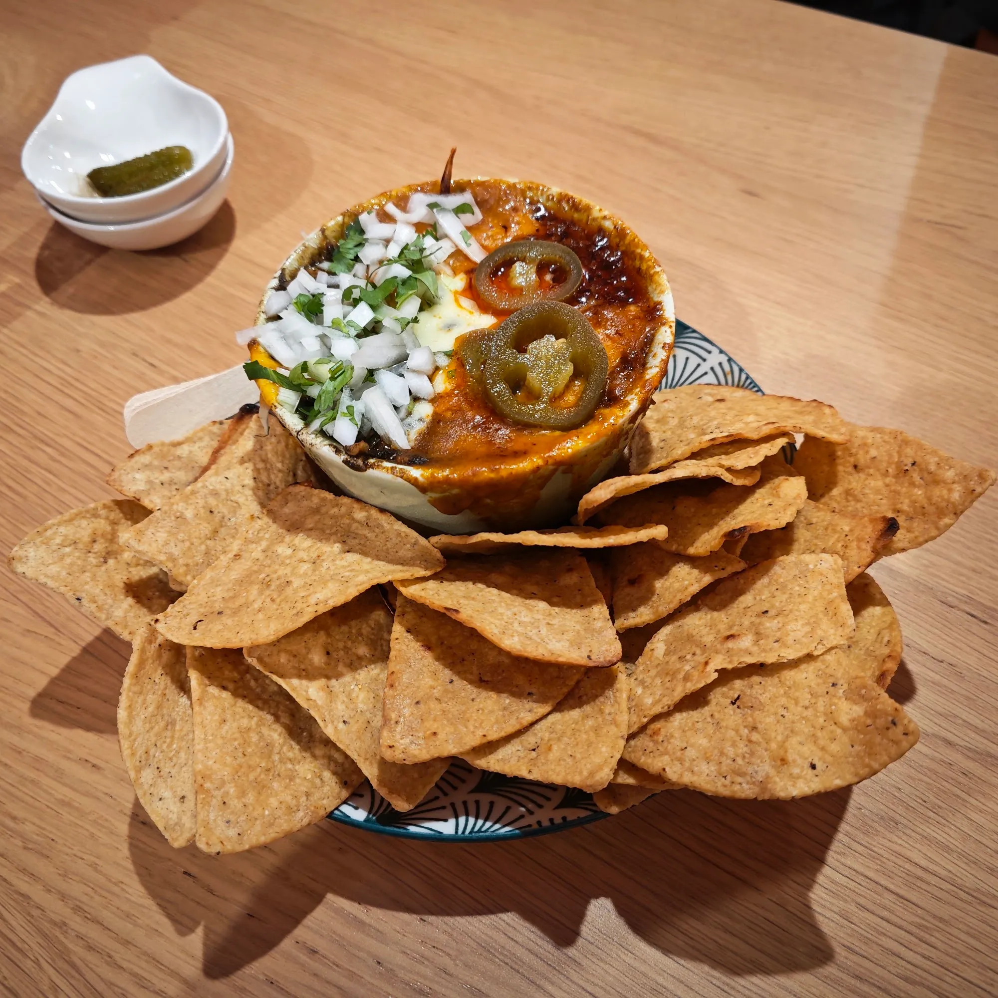 Volcán servido sobre totopos con salsa verde y jalapeños